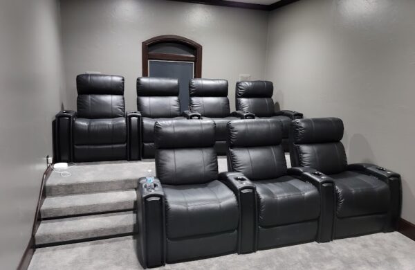 Two tiered media room with black leather seating